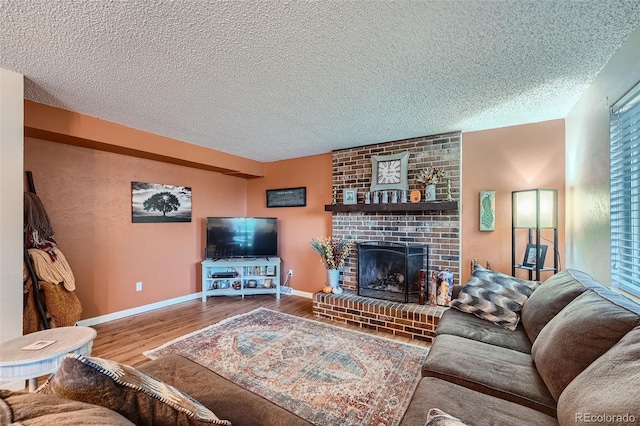 living room with a textured ceiling, a brick fireplace, and hardwood / wood-style flooring