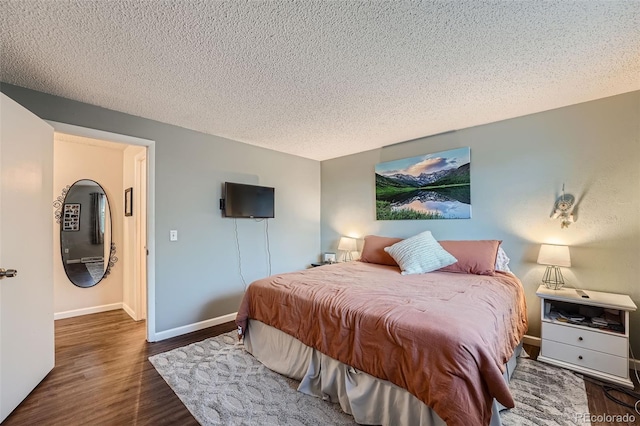 bedroom with dark wood-type flooring and a textured ceiling