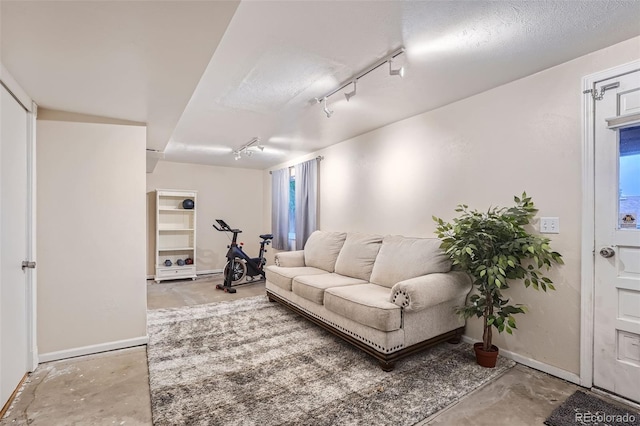 living room featuring rail lighting and concrete floors