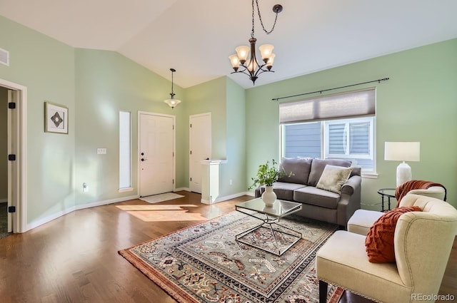 living room featuring an inviting chandelier, lofted ceiling, and wood-type flooring