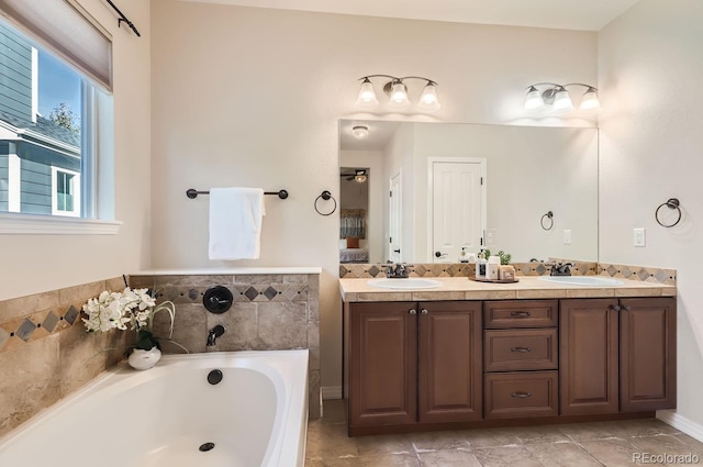 bathroom with a tub to relax in, vanity, and tile patterned flooring