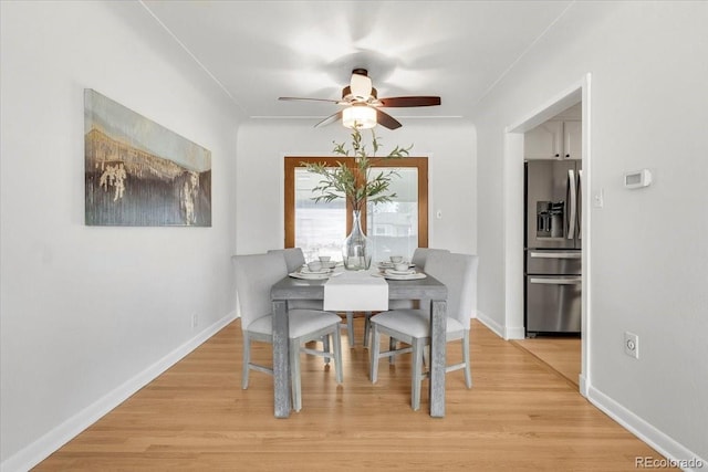 dining room featuring a ceiling fan, baseboards, and light wood-type flooring