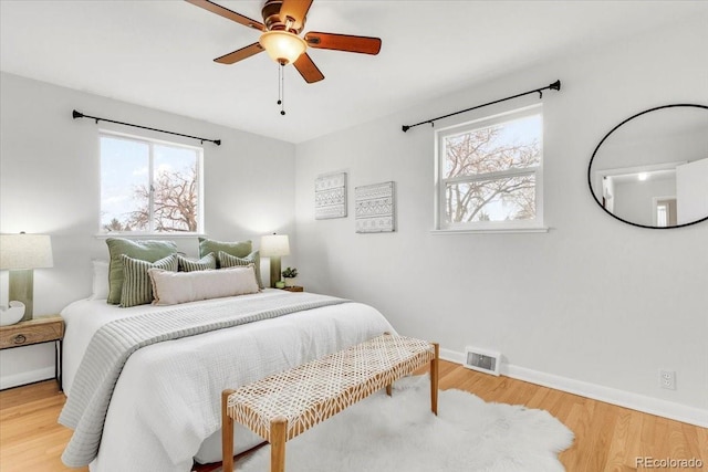 bedroom with visible vents, ceiling fan, baseboards, and wood finished floors