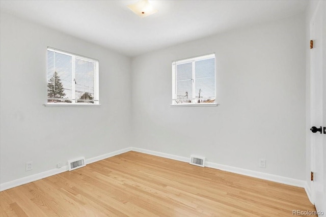 unfurnished room with light wood-style flooring, baseboards, and visible vents