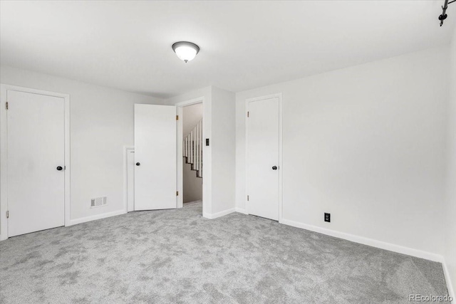 unfurnished bedroom with baseboards, visible vents, and carpet floors