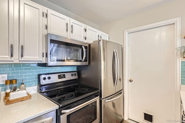 kitchen featuring visible vents, white cabinetry, appliances with stainless steel finishes, decorative backsplash, and light stone countertops