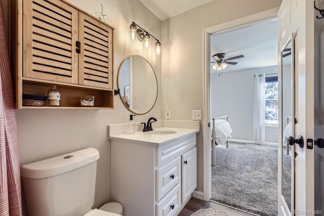 bathroom with toilet, baseboards, a ceiling fan, and vanity