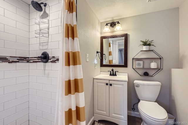 full bath with tiled shower, vanity, and toilet