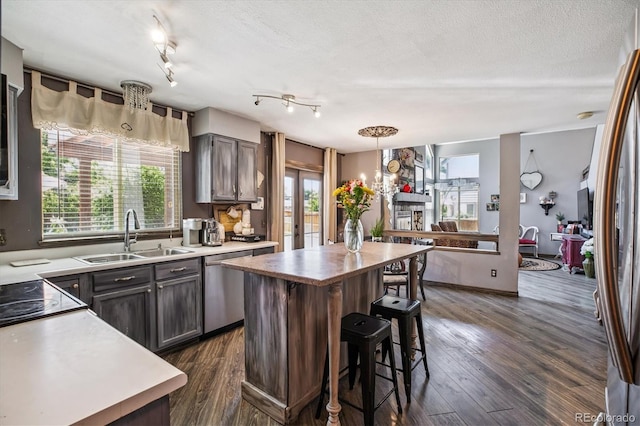 1744 Brookside Dr, Highlands Ranch, CO 80126 - kitchen with stainless steel appliances, a center island, a kitchen breakfast bar, dark wood-style flooring, and a textured ceiling