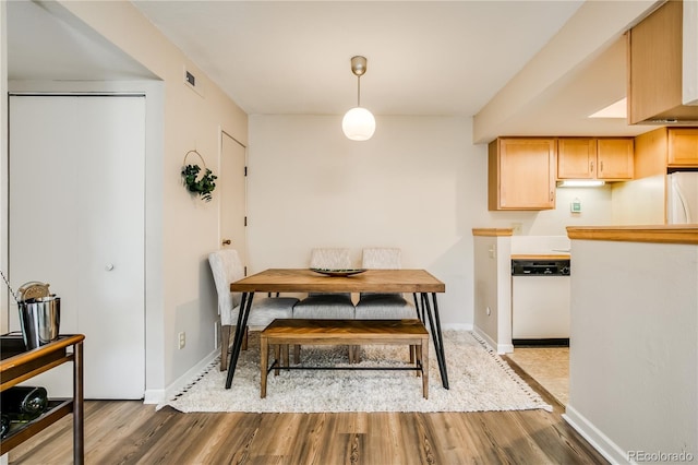 dining area featuring dark wood-style flooring, visible vents, and baseboards