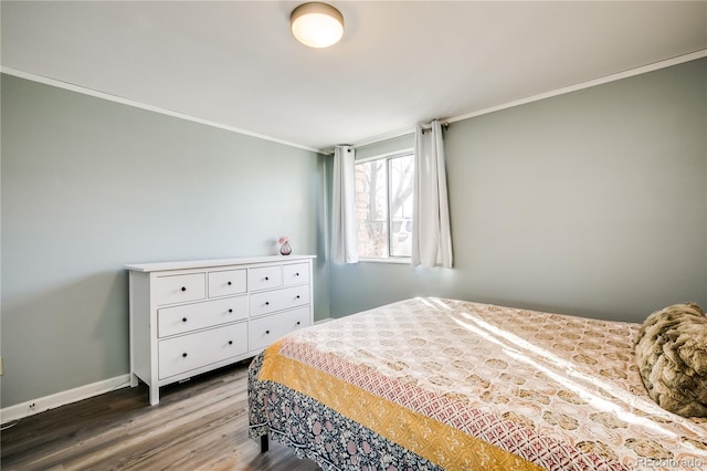 bedroom featuring baseboards, ornamental molding, and wood finished floors