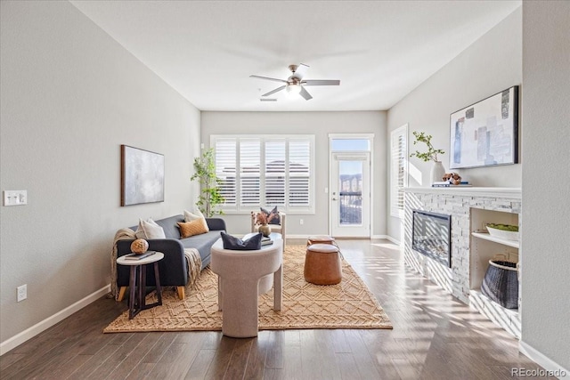 living room with ceiling fan, a fireplace, and dark hardwood / wood-style flooring