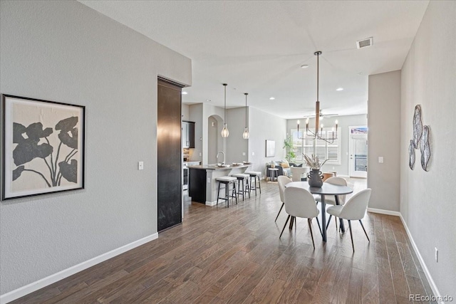 dining space featuring dark hardwood / wood-style floors, a chandelier, and sink