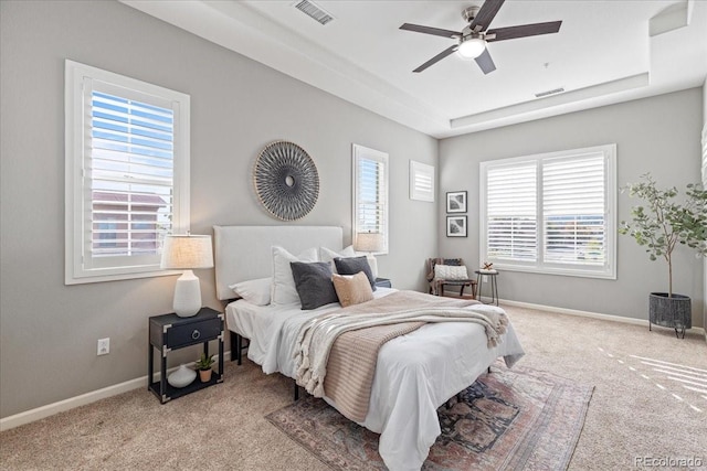 bedroom featuring light colored carpet, multiple windows, and ceiling fan