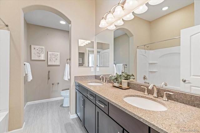 full bathroom with hardwood / wood-style flooring, bathtub / shower combination, vanity, and toilet