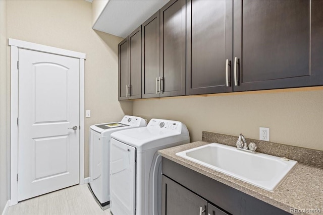 washroom with independent washer and dryer, sink, and cabinets