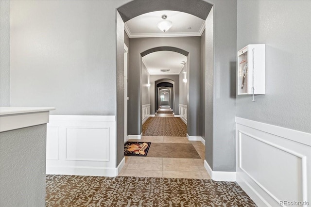 hall featuring ornamental molding and light tile patterned floors