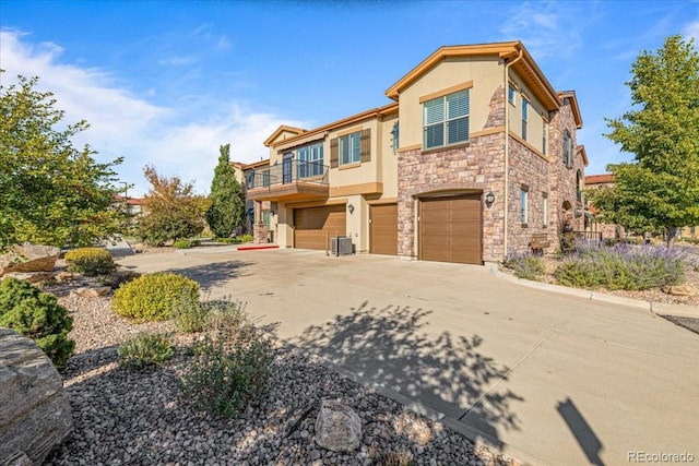 view of front of house with a garage, a balcony, and central AC unit