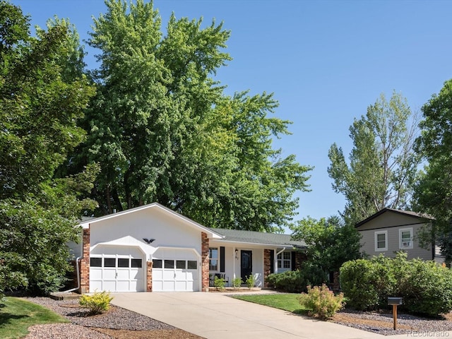 1067 E 15th Ave, Broomfield, CO 80020 - view of front of house with a garage, concrete driveway, and brick siding