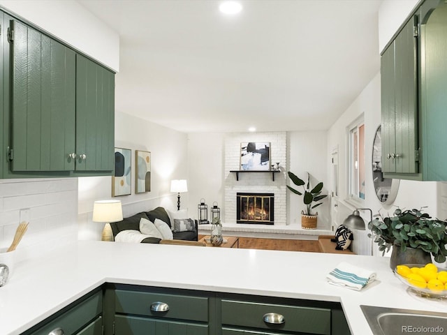 1067 E 15th Ave, Broomfield, CO 80020 - kitchen with green cabinets, light countertops, open floor plan, tasteful backsplash, and a fireplace