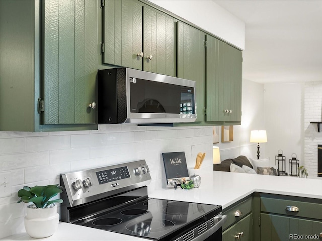 1067 E 15th Ave, Broomfield, CO 80020 - kitchen featuring stainless steel appliances, green cabinetry, decorative backsplash, light countertops, and open floor plan