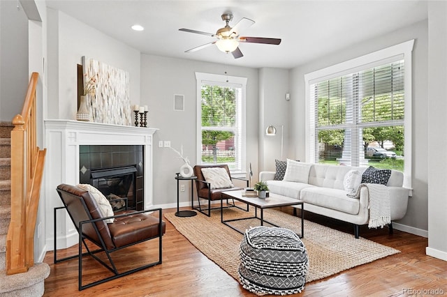 9134 E 29th Pl, Denver, CO 80238 - living room with a ceiling fan, wood finished floors, baseboards, a tiled fireplace, and stairs