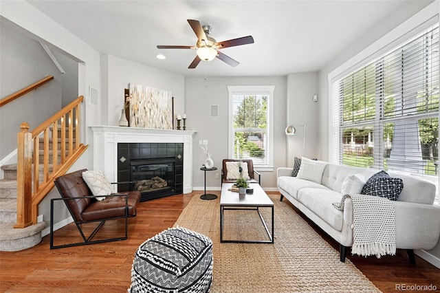 9134 E 29th Pl, Denver, CO 80238 - living area featuring wood finished floors, a tile fireplace, ceiling fan, stairs, and baseboards