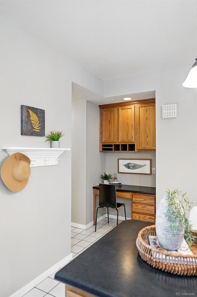 9134 E 29th Pl, Denver, CO 80238 - kitchen featuring light tile patterned flooring, dark countertops, brown cabinets, and baseboards