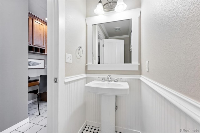 9134 E 29th Pl, Denver, CO 80238 - bathroom featuring a wainscoted wall, tile patterned floors, a sink, ornamental molding, and a textured wall