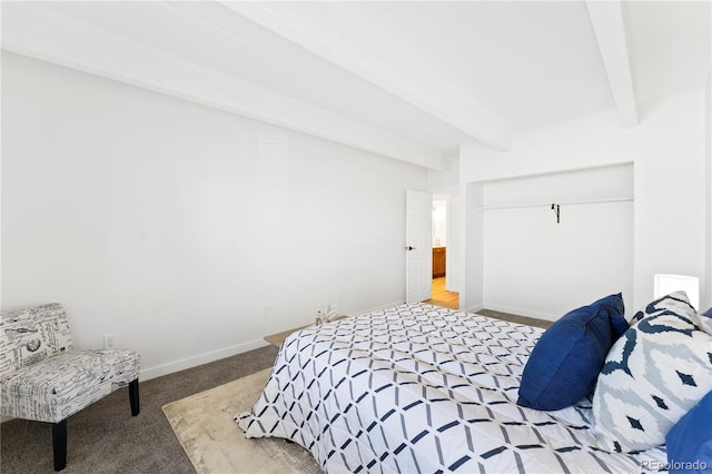 bedroom with a closet, beamed ceiling, and carpet flooring