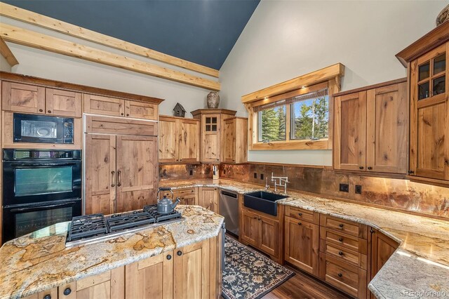 2655 Hunters Knob Rd, Silverthorne, CO 80498 - kitchen featuring black appliances, a center island, light stone counters, glass insert cabinets, and high vaulted ceiling