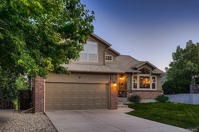12534 W Hoover Ave, Littleton, CO 80127 - view of front of home featuring brick siding, concrete driveway, and a garage