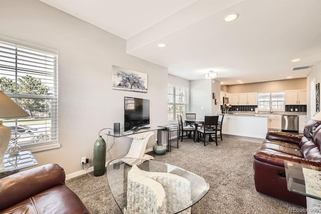 202 Ash St, Bennett, CO 80102 - living area featuring light colored carpet, healthy amount of natural light, recessed lighting, and baseboards