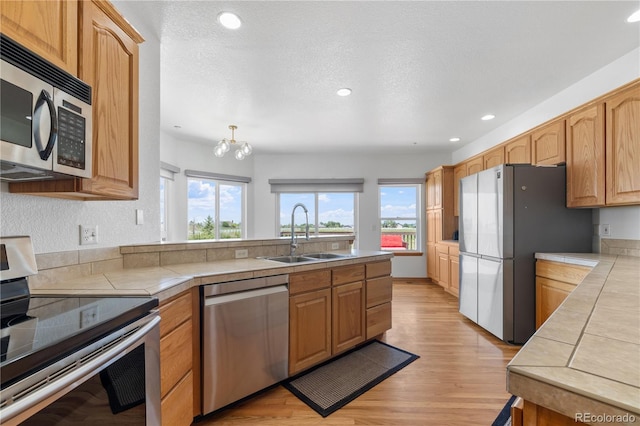 34771 E 153rd Ct, Hudson, CO 80642 - kitchen with stainless steel appliances, tile counters, plenty of natural light, light wood-type flooring, and recessed lighting