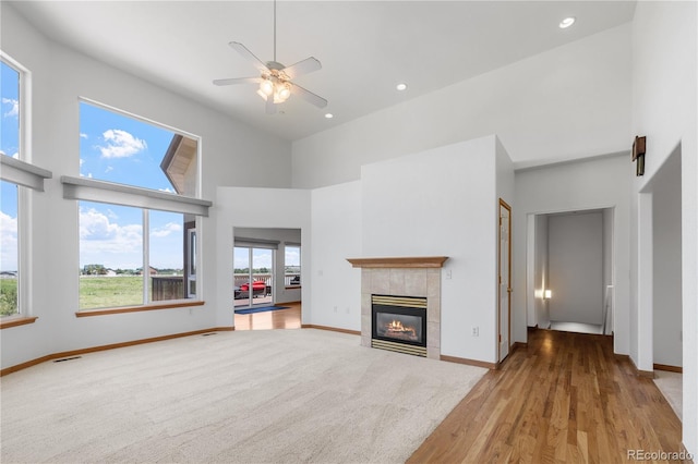 34771 E 153rd Ct, Hudson, CO 80642 - unfurnished living room with a high ceiling, ceiling fan, a tile fireplace, recessed lighting, and wood finished floors