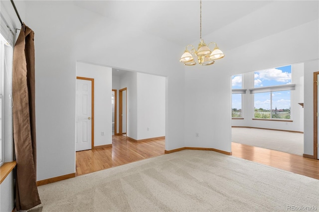 34771 E 153rd Ct, Hudson, CO 80642 - unfurnished room featuring carpet flooring, a chandelier, high vaulted ceiling, and wood finished floors