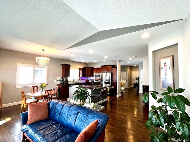 living room with vaulted ceiling, a textured ceiling, a notable chandelier, and dark hardwood / wood-style flooring