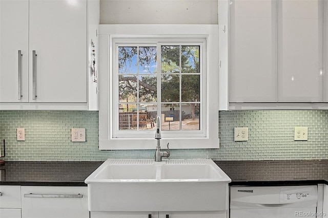 825 Hill Road Ct, Colorado Springs, CO 80909 - kitchen with white dishwasher, a sink, dark countertops, and white cabinetry