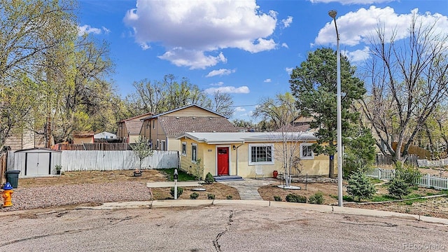 825 Hill Road Ct, Colorado Springs, CO 80909 - view of front of property with a shed, stucco siding, fence, and an outdoor structure