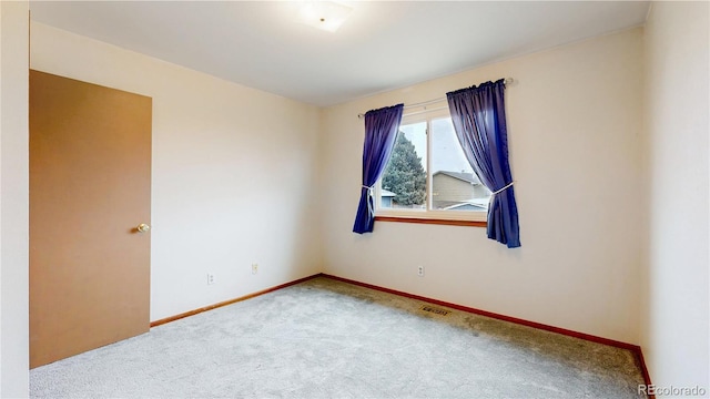 unfurnished room with carpet flooring and baseboards