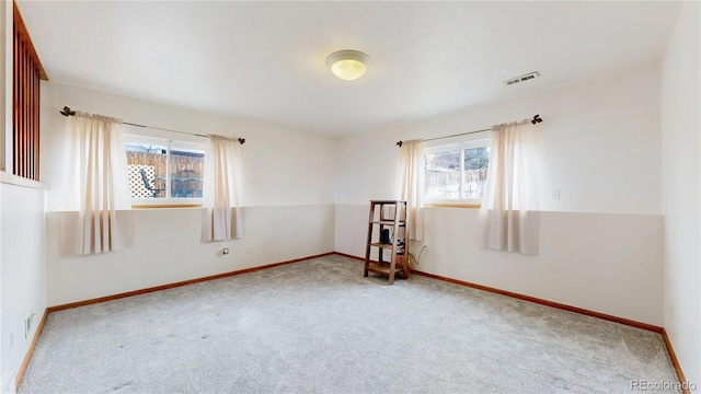 carpeted empty room featuring baseboards