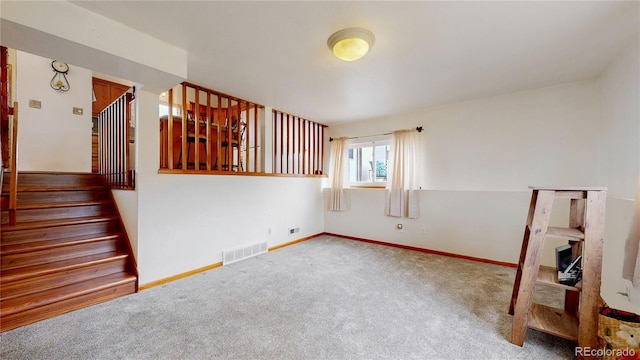 carpeted empty room with stairs and baseboards