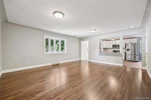 4560 S Fox St, Englewood, CO 80110 - unfurnished living room with a textured ceiling and wood finished floors