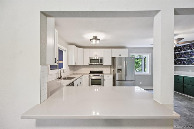 4560 S Fox St, Englewood, CO 80110 - kitchen with appliances with stainless steel finishes, light countertops, white cabinets, and decorative backsplash