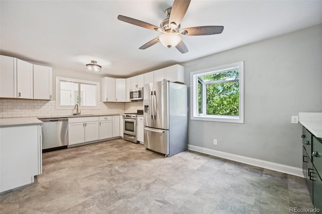 4560 S Fox St, Englewood, CO 80110 - kitchen featuring appliances with stainless steel finishes, a ceiling fan, tasteful backsplash, and white cabinetry