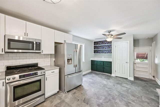 4560 S Fox St, Englewood, CO 80110 - kitchen featuring stainless steel appliances, white cabinets, backsplash, and healthy amount of natural light