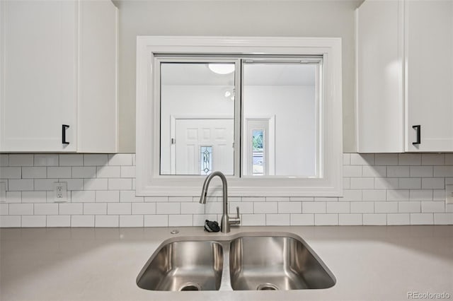 4560 S Fox St, Englewood, CO 80110 - kitchen with light countertops, white cabinetry, and backsplash