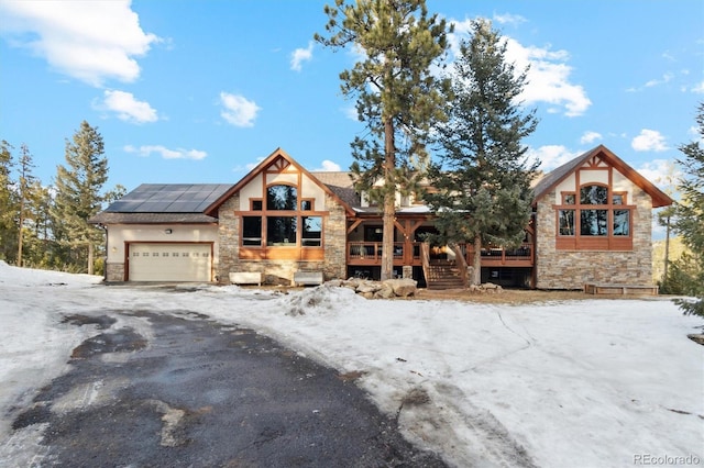 view of front of property featuring a garage and solar panels