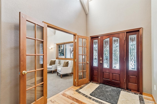 foyer entrance with french doors and light hardwood / wood-style flooring