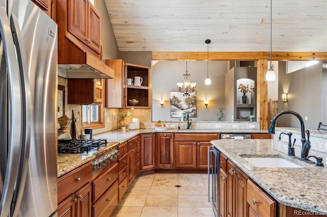 kitchen featuring appliances with stainless steel finishes, sink, pendant lighting, and light stone counters